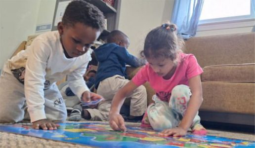 Loving teacher guiding toddlers in Montessori classroom