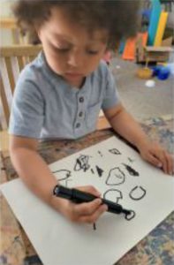Loving teacher guiding toddlers in Montessori classroom